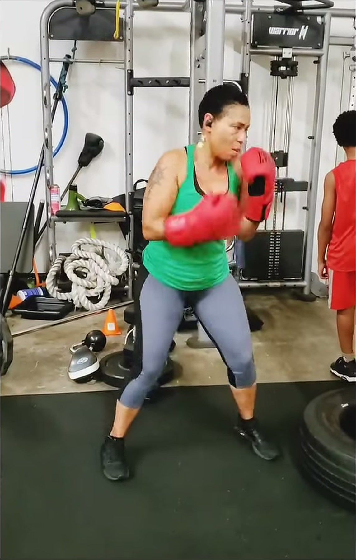 A client in boxing gloves holding her guard during a session at Warrior Fit Boxing